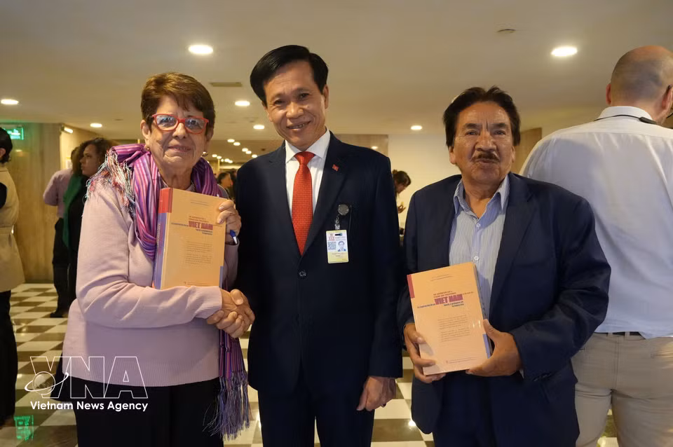 Assoc. Prof. Dr. Hoang Phuc Lam presents copies of the book to delegates attending the seminar. (Photo: Phi Hung/VNA correspondent in Mexico)