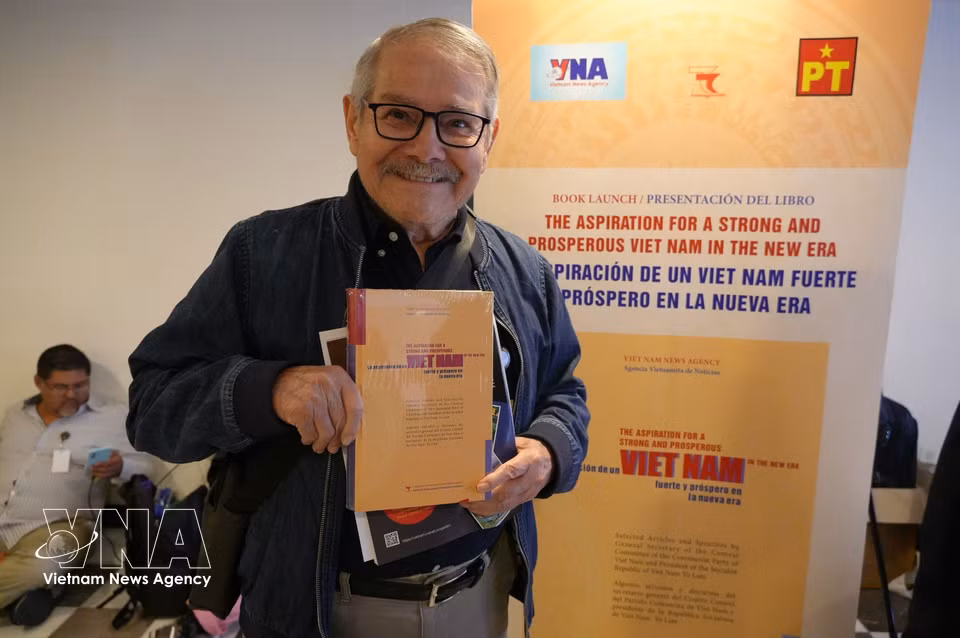 A delegate holds a copy of the book “The Aspiration for a Strong and Prosperous Viet Nam in the New Era,” a collection of selected articles and speeches by Vietnamese Party General Secretary and President To Lam. (Photo: Phi Hung/VNA correspondent in Mexico)