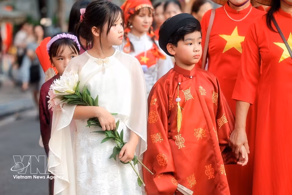 Children in traditional Vietnamese costumes take part in the “Colours of the World” street festival. (Photo: VNA)