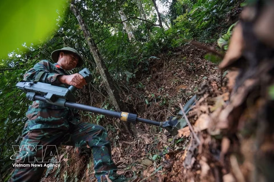 Detection equipment is used to locate and clear unexploded ordnance and other explosive remnants of war in areas where searches and recovery operations for fallen soldiers' remains are being carried out. (Photo: VNA)