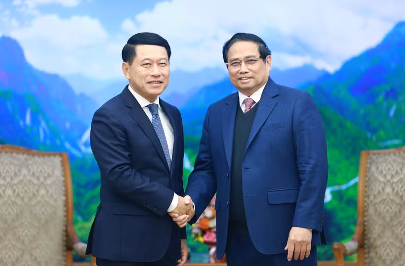 Prime Minister Pham Minh Chinh (R) receives visiting Lao Deputy Prime Minister Saleumxay Kommasith in Hanoi on December 30. (Photo: VNA)