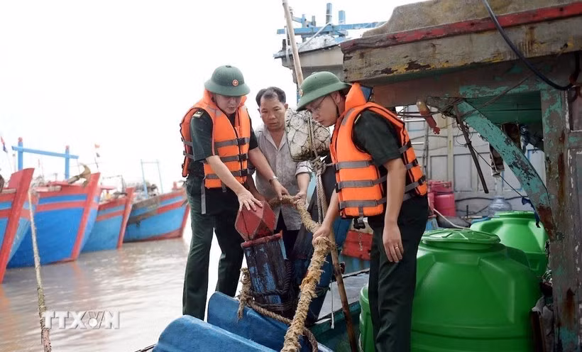 Military officers assist fishermen in Hai Thinh commune, Ninh Binh province, to gear up for the storm. (Photo: VNA)