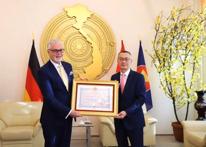 Vietnamese Ambassador to Germany Vu Quang Minh (R) presents the Friendship Order to Dr. Guido Hildner, former Ambassador of Germany to Vietnam, in Berlin on October 9. (Photo: VNA)