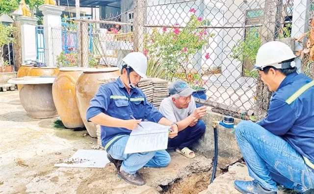 Workers from the Can Gio Clean Water Supply Company install smart water meters in Tam Thon Hiep commune, Can Gio district. (Photo: nhandan.vn) 
