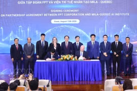 Deputy Prime Minister Ho Quoc Dung (fifth from left) and delegates witness the signing of the strategic cooperation agreement for the next phase between FPT Corporation and Mila – Quebec AI Institute of Canada. (Photo: VNA)