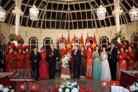 General Secretary of the Communist Party of Vietnam Central Committee and President To Lam (8th from left, first row) and his spouse Ngo Phuong Ly, and Swiss President Guy Parmelin and his spouse Caroline Parmelin present flowers to artists performing at the banquet. (Photo: VNA)