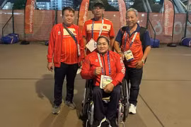 Nguyen Thi Ngoc Thuy with her coach and representatives of the Vietnamese delegation. (Photo: Vietnam Paralympic Committee)