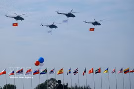 Helicopters perform a flypast at the opening ceremony of the Vietnam Defence Expo 2024. (Photo: VNA)