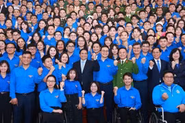Prime Minister Pham Minh Chinh and officials pose for a group photo with young people at the dialogue on March 24. (Photo: VNA)
