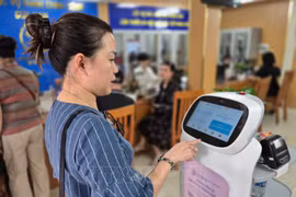 Woman experiences an AI-powered robot that applies AI technology to assist with administrative procedures at Cua Nam ward, Hanoi. (Photo: VNA) 