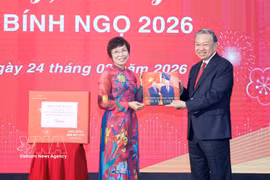 VNA General Director Vu Viet Trang (L) presents a photo book to Party General Secretary To Lam. (Photo: VNA)