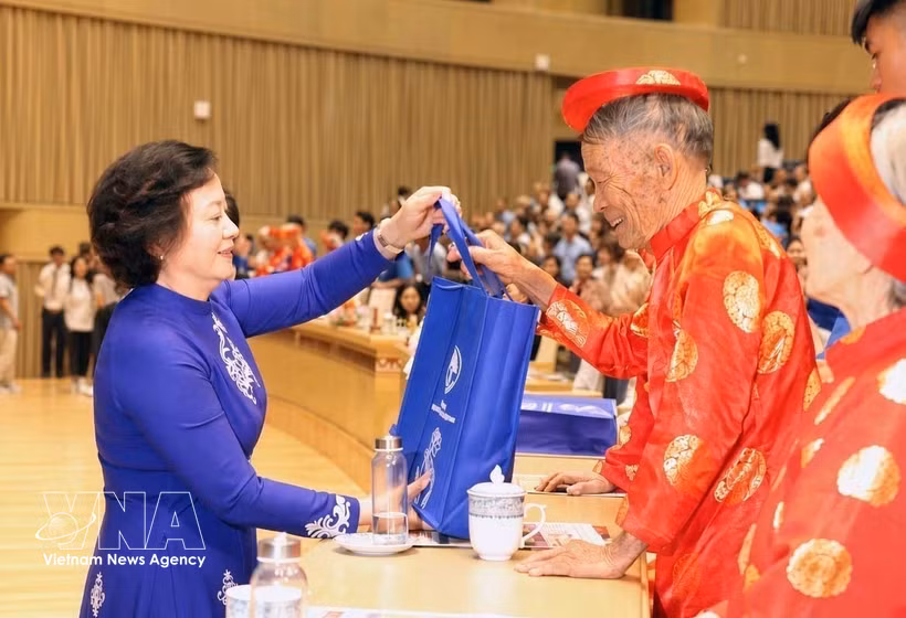 ​Deputy Prime Minister and Chairwoman of the National Committee for the Elderly Pham Thi Thanh Tra (L) presents gifts to the elderly. (Photo: VNA)