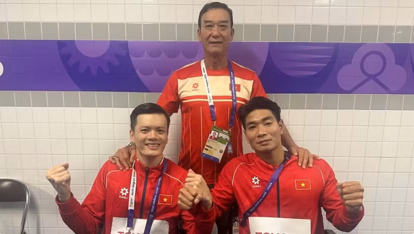 Coach Dang Vien together with swimmers Do Thanh Hai and Le Tien Dat (Photo: nhandan.vn)