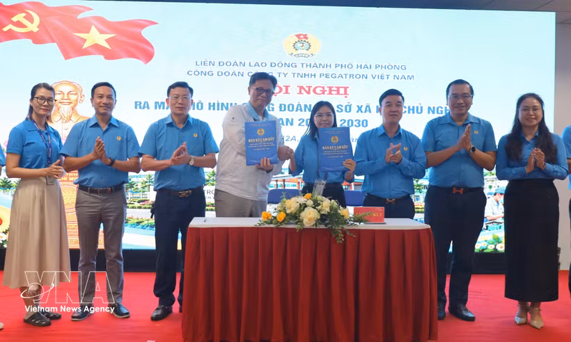 A leader of Pegatron Vietnam Co., Ltd. sign an agreement with the firm's trade union. (Photo: VNA)