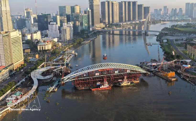 The main span of the pedestrian bridge is tugged to the construction site on October 21, 2026. (Photo: VNA)