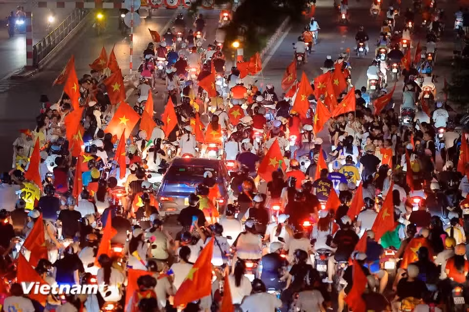Images of President Ho Chi Minh and the red flag with a yellow star appear on the streets on the night of Vietnam’s football triumph. (Photo: VietnamPlus)