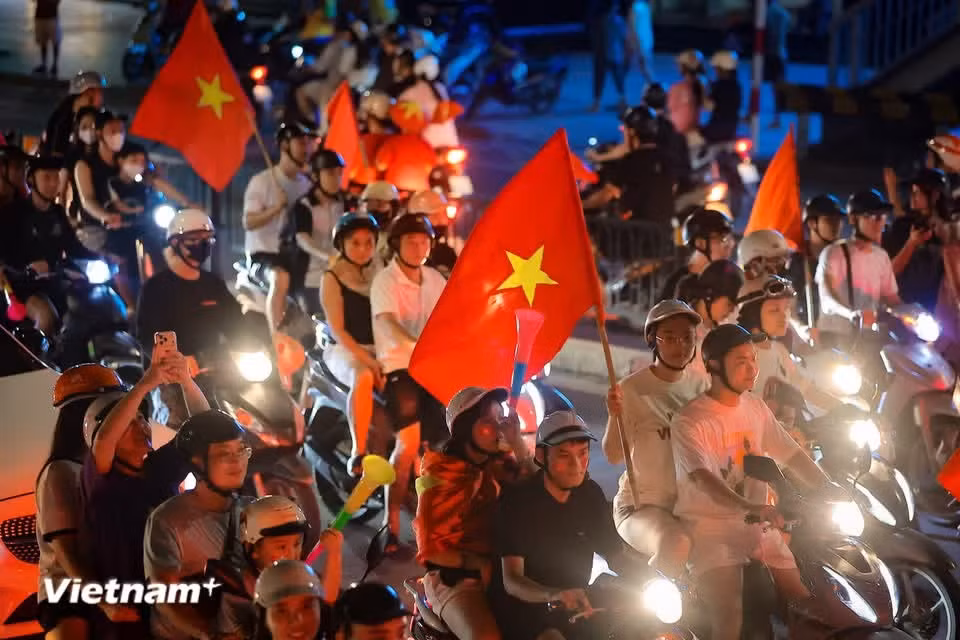 Car horns and vuvuzelas blare alongside the rhythmic clanging of metal trays, pots and pans, a rousing symphony that echoes through the night. (Photo: VietnamPlus)