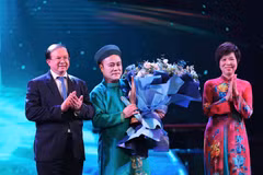 Vietnam News Agency General Director Vu Viet Trang (R) and Deputy Minister of Culture, Sports and Tourism Ta Quang Dong (L) present the "Inspiring Artist" Award to artist Chu Bao Que. (Photo: VNA)