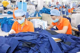 Workers make garments for export at a Viet Hung Textile Garment Company'. (Photo: VNA/VNS)