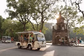 Tourists ride around Hoan Kiem Lake on electric shuttle vehicles. (Photo: VNA)