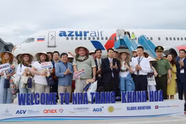 Russian tourists pose for photos with representatives from Khanh Hoa province (Photo: VNA)