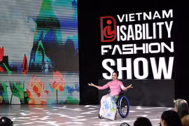 A model with physical challenge confidently showcase ao dai (Vietnamese traditional long dress) on the fashion runway. (Photo: VNA)