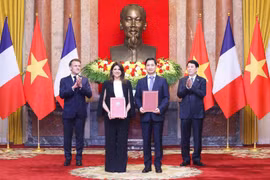 On the morning of May 26, 2025, following bilateral talks at the Presidential Palace, President Luong Cuong (first, right) and French President Emmanuel Macron (first, left) witness the exchange of cooperation documents between leaders of ministries, agencies, and enterprises from both countries. In the photo: Ngo Chi Dung, General Director and Chairman of the Board of Viet Nam Vaccine Company (VNVC) (second, right), and Zainab Sadat Qayyum, President of Sanofi Southeast Asia – India, exchange the cooperation agreement on the transfer of Sanofi’s vaccine production technology to VNVC’s vaccine and biologicals plant. (Photo: VNVC)