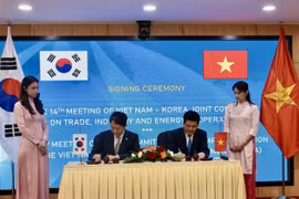 Vietnamese Minister of Industry and Trade Nguyen Hong Dien (R) and Korean Minister of Trade, Industry and Energy Ahn Dukgeun sign cooperation documents in the meeting. (Photo: VNA)