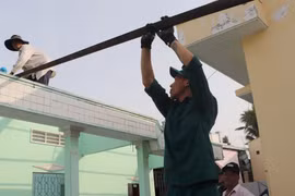 Long My township's armed forces assist residents in eliminating temporary and dilapidated houses. (Photo: VNA)