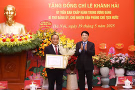 State President Luong Cuong presents a 40-year Party membership badge to Le Khanh Hai, member of the Party Central Committee and head of the Presidential Office at a ceremony on May 19 in Hanoi. (Photo: VNA)