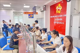 Civil servants and citizens carry out administrative procedures at the public administrative service centre of Tien Dien commune, Ha Tinh province. (Photo: VNA)
