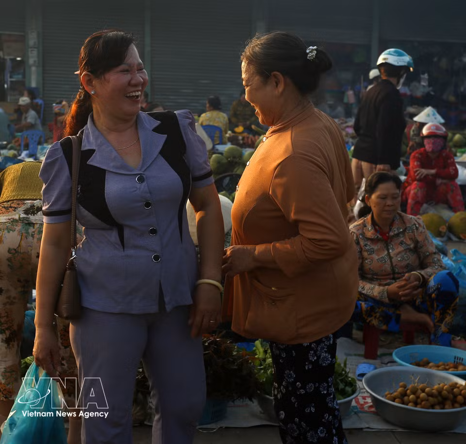 Vendors and shoppers have friendly conversations at the market. (Photo: Duy Khuong/VNA)