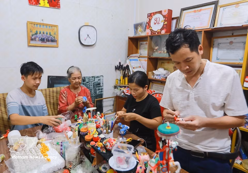 Three generations of artisan Dang Van Hau’s family carry on the traditional To He craft. (Khanh Hoa/VNA)