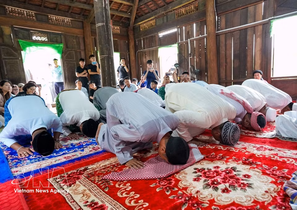 Cham Muslim men in traditional attire head to the mosque together for prayers. (Photo: Khanh Hoa/VNA)