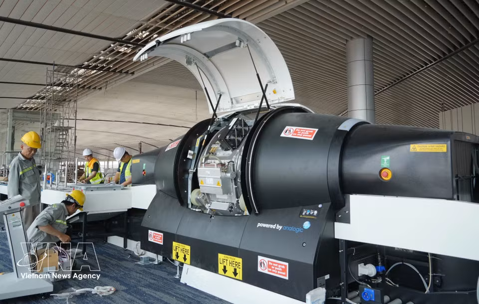 Workers inspect and install components of the 3D scanners for cabin baggage at Long Thanh Airport. (Photo: Cong Phong/VNA)