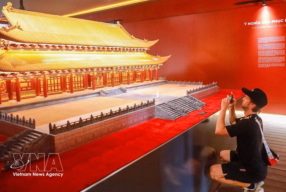 A visitor looks at a reconstruction model of Kinh Thien Palace displayed at the exhibition. (Photo: Khanh Hoa/VNA)