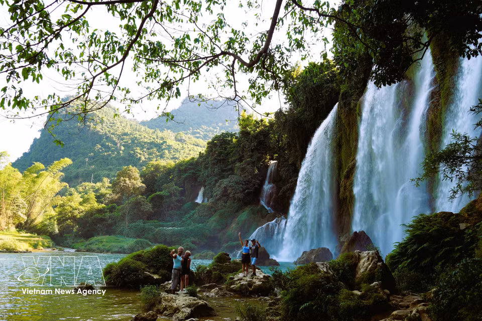 Foreign visitors take photos of Ban Gioc Waterfall. (Photo: Chu Hieu/VNA)