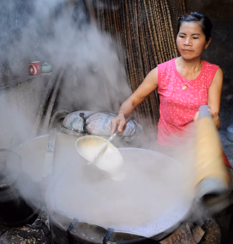 Rice paper steaming process in Tho Ha. (Photo: VNA)