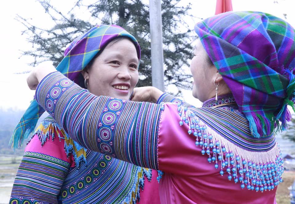 Mong women help each other adjust their traditional attire before joining the festival. (Photo: VNA)