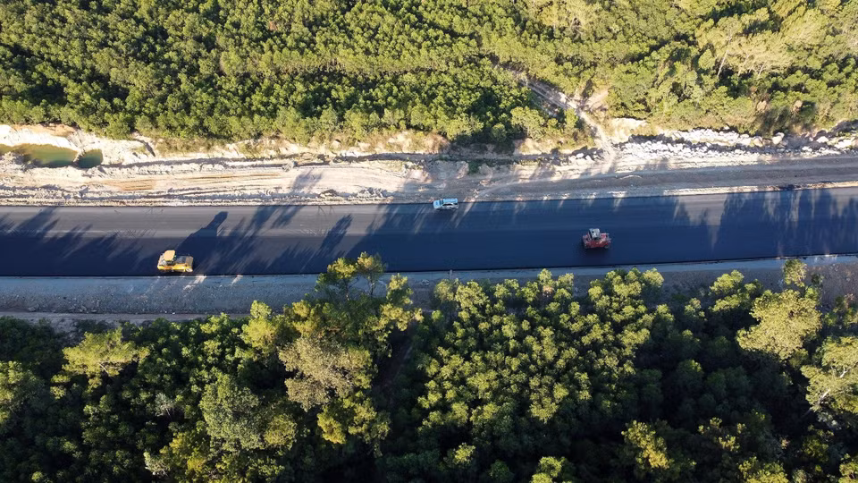 The contractor applies a final layer of asphalt on the surface of the Nghi Son - Dien Chau expressway section. (Photo: VNA)