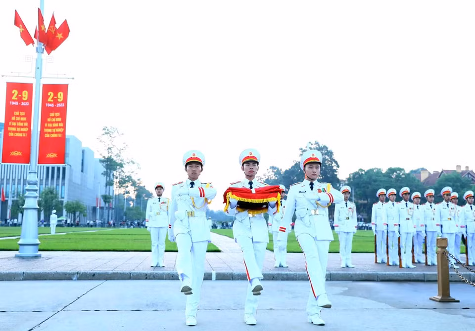 Soldiers carry the national flag towards the flagpole to prepare for the ceremony. (Photo: VNA)