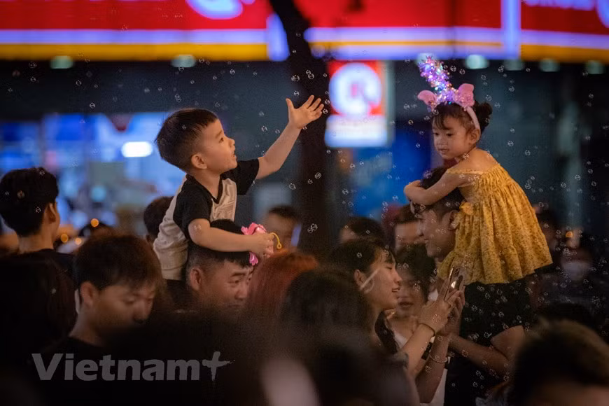 Families bring their kids to Hang Ma to enjoy the festive atmosphere. (Photo: Vietnamplus)