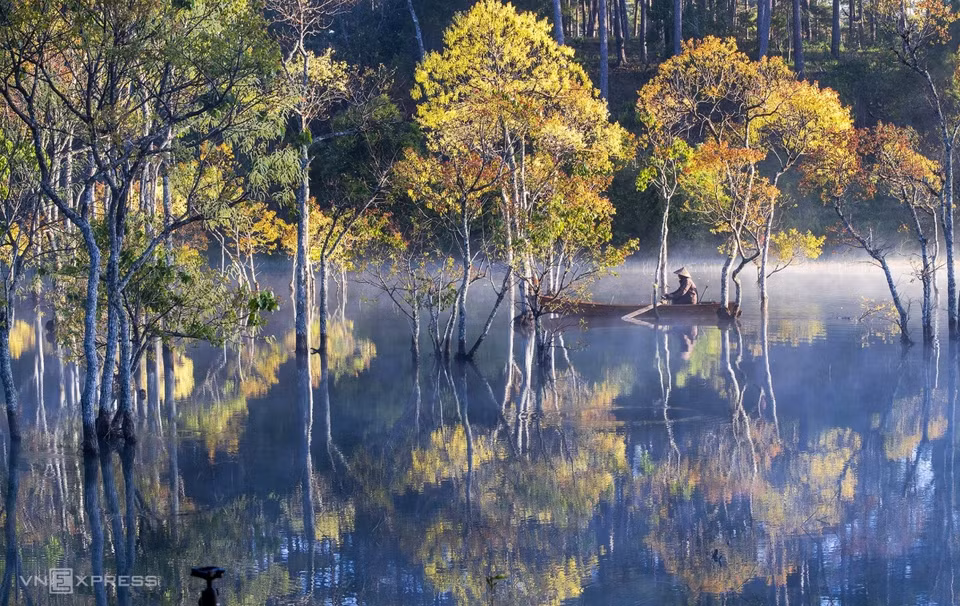 A man rows his boat amid hollong trees that rise from the waters on Tuyen Lam Lake in the early morning mist.Around six kilometers to the south of downtown Da Lat, Tuyen Lam Lake is among the best places to capture stunning misty mornings. Many photos of this landscape have been featured in U.S.-based Natgeo magazine. (Photo: vnexpress.net)
