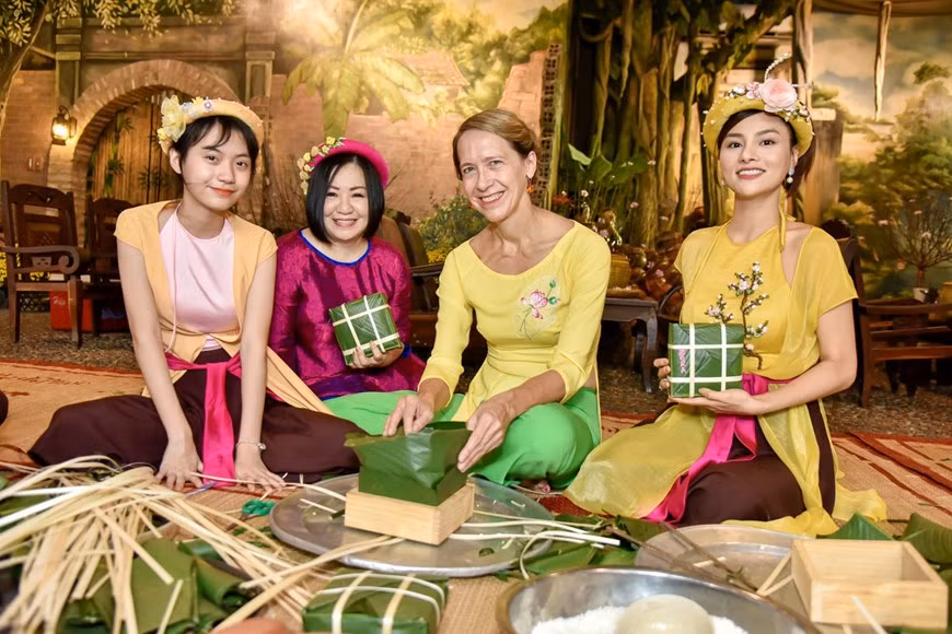 Foreigners enjoy wrapping Banh chung, traditional cake of Vietnamesee people during Tet holiday. (Photo: Vietnamplus) (Photo: Vietnamplus)