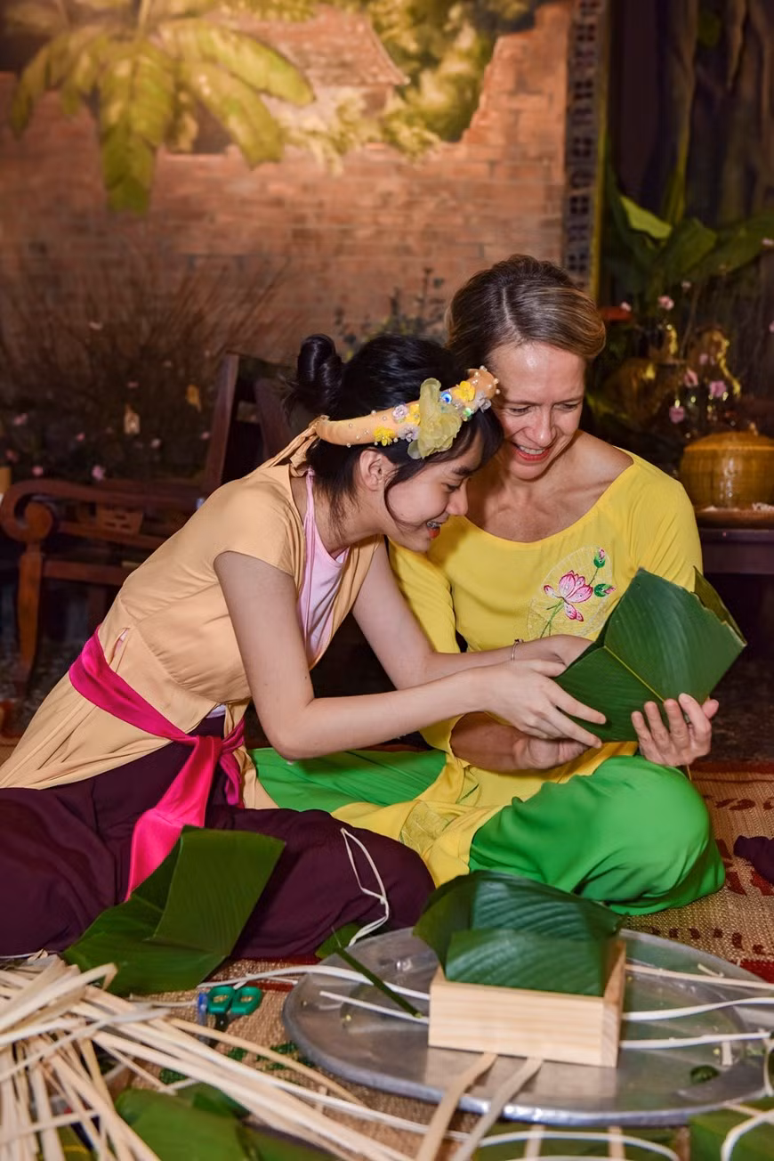  A foreign visitor enjoys wrapping Banh chung, traditional cake of Vietnam's Lunar New Year holiday. (Photo: Vietnamplus)