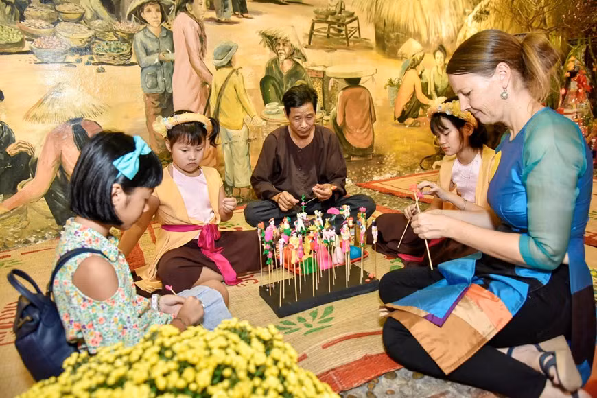 Making “to he” figurines with artisans (Photo: Vietnamplus)