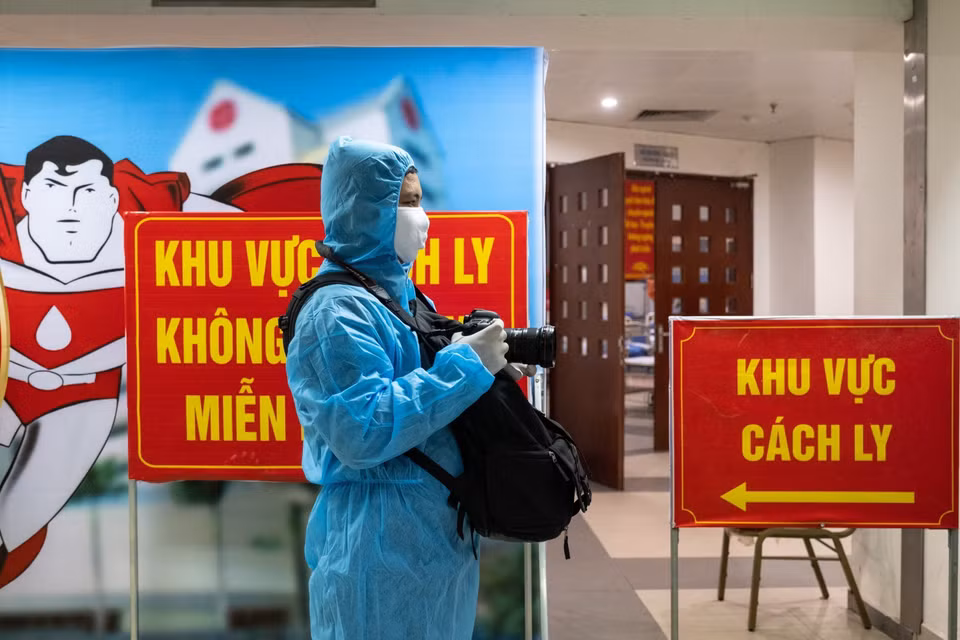 Minh Quyet, journalist from Vietnam News Agency’s Press Photography Department, works in a COVID-19 quarantine zone of the National Institute of Haematology and Blood Transfusion. (Photo: VNA)