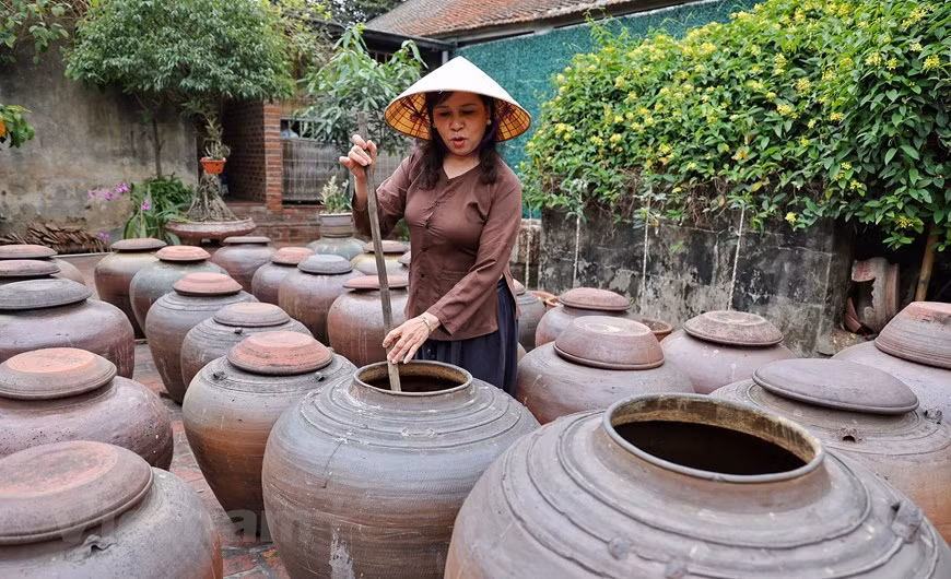 The family of Ha Huu The still preserves the traditional making of ‘tuong’, a type of fermented condiment from soya bean. No one in Duong Lam has any idea when the first soya sauce was made in the village. The sauce is made from glutinous rice, soybeans, corn and salt with the use of stone mortars, copper pans, steamers, frying pans, baskets and jars. Soy sauce makers choose their materials very carefully. They make soya sauce mostly in May and June because this time of the year is optimum for the work. Duong Lam villagers continue to make soy sauce by hand and, for them, rainwater is an indispensable ingredient (Photo: VietnamPlus)