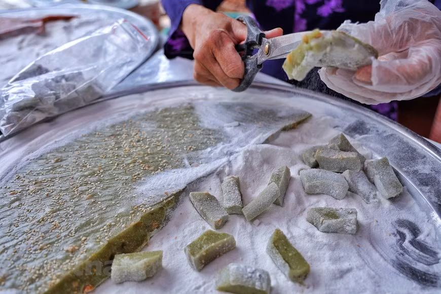Nowadays, residents in Duong Lam have come up with several new variants of ‘che lam’ by adding ingredients like gac fruit and pandan leaves, making it more fragrant, colorful and flavourful. This picture shows ‘che lam’ with its green colour coming from pandan leaves. The rice used to make che lam is the golden flower glutinous rice, one of best varieties in Vietnam, grown only in the north of the country. First, the rice is roasted and ground into a smooth flour. Then it is cooked with water, sugar and ginger, stirred continuously to get the mixture thick. When the mixture is still hot, peanuts are added to give it a buttery, crunchy taste. (Photo: VietnamPlus)