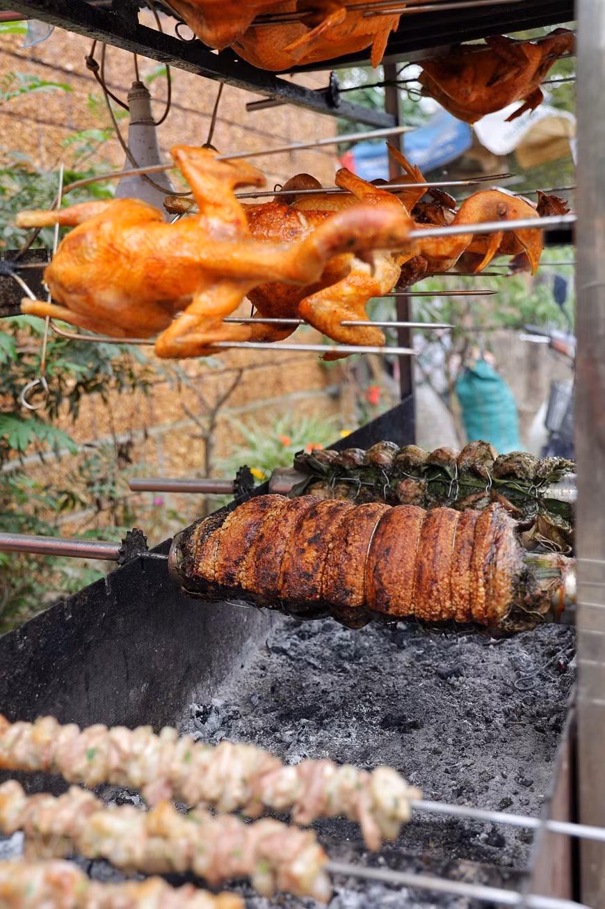 Locals have to get up at 3am since it takes them nearly eight hours and many complicated steps to create roasted pork like this. The bacon is marinated with pepper, garlic, chillies, onion, fish sauce and chopped guava leaves. It is traditionally wrapped around a large bamboo pole lined with banana leaves inside. The pork is grilled on charcoal for 10 minutes and then will be pierced with a sharp needle to make the fat melt. After that, it is washed with salt water that is added with some lemon juice to make the skin crispy and clean. The meat is then roasted for 3 - 5 hours. (Photo: VietnamPlus)